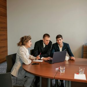 Professional setup of three people discussing a project in an office environment.