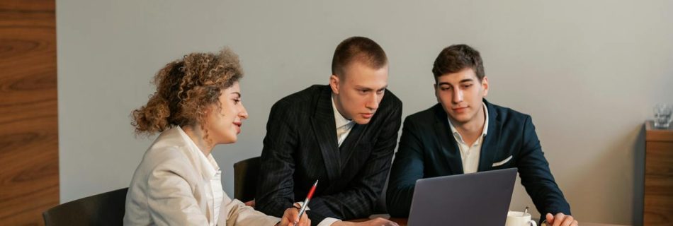 Professional setup of three people discussing a project in an office environment.